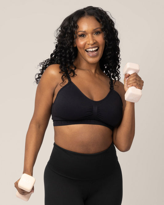 Model wearing the Sublime® Nursing Sports Bra in Black holding two hand weights and exercising. @model_info:Rashé is wearing a Large.